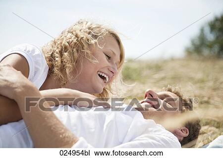 Stock Image - young couple lying in field in summer. Fotosearch