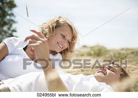 Stock Image - young couple lying in field in summer. Fotosearch