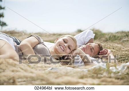 young couple lying in field in summer View Large Photo Image Stock Image - young couple lying in field in summer. Fotosearch
