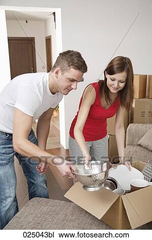 young couple packing crockery in cardboard boxes View Large Photo Image Stock Image - young couple packing crockery in cardboard boxes. Fotosearch