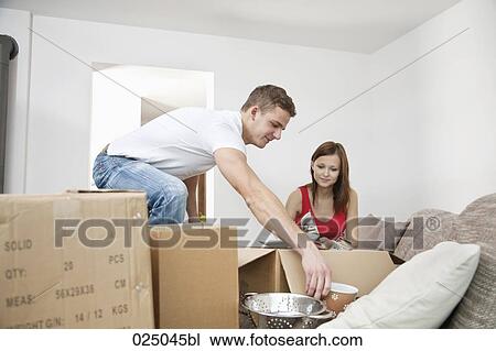 young couple packing crockery in cardboard boxes View Large Photo Image Stock Image - young couple packing crockery in cardboard boxes. Fotosearch