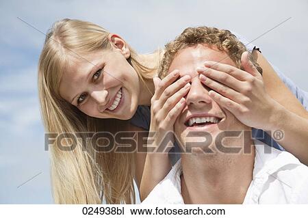 Stock Image - young couple playing peekaboo. Fotosearch