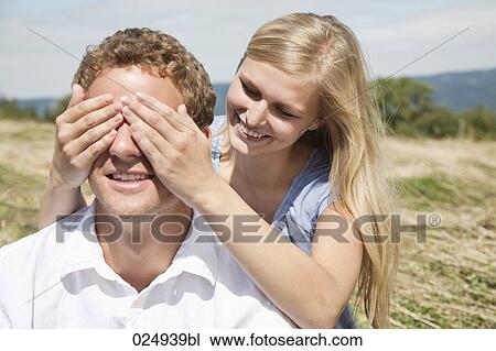 Stock Image - young couple playing peekaboo. Fotosearch