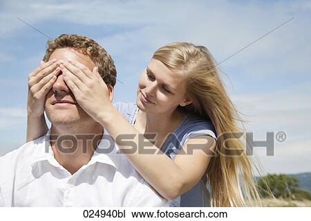 Stock Image - young couple playing peekaboo. Fotosearch