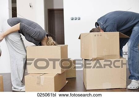 Stock Image - young couple searching for something in moving boxes. Fotosearch