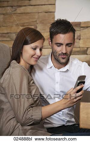 young couple sharing message on mobile phone at restaurant View Large Photo Image Stock Image - young couple sharing message on mobile phone at restaurant. Fotosearch