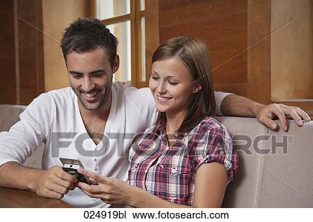 young couple sharing text message on mobile phone View Large Photo Image Stock Image - young couple sharing text message on mobile phone. Fotosearch