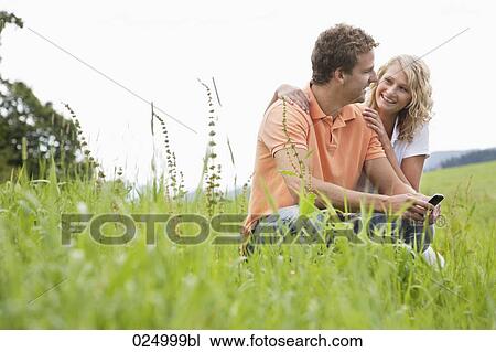 young couple sitting in meadow View Large Photo Image Stock Image - young couple sitting in meadow. Fotosearch