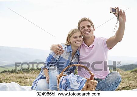 young couple taking picture of themselves with digital camera View Large Photo Image Stock Image - young couple taking picture of themselves with digital camera. Fotosearch