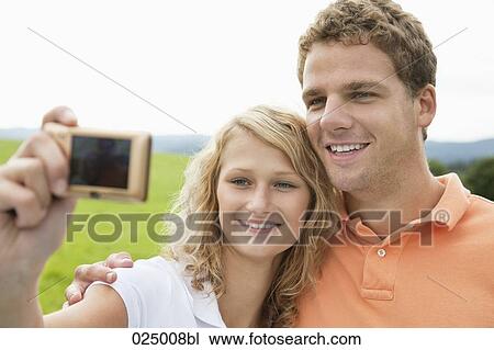 young couple taking self-portrait with digital camera View Large Photo Image Stock Image - young couple taking self-portrait with digital camera. Fotosearch