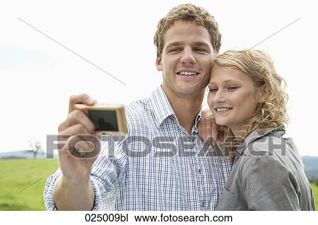 young couple taking self-portrait with digital camera View Large Photo Image Stock Image - young couple taking self-portrait with digital camera. Fotosearch