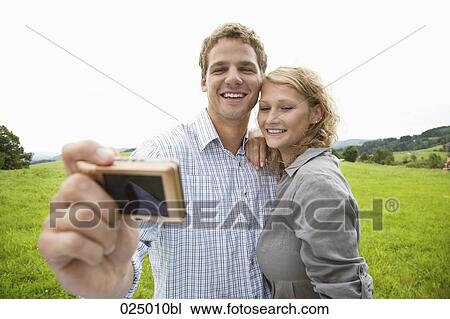young couple taking self-portrait with digital camera View Large Photo Image Stock Image - young couple taking self-portrait with digital camera. Fotosearch