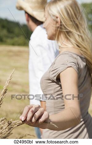 Stock Image - young couple walking through field. Fotosearch
