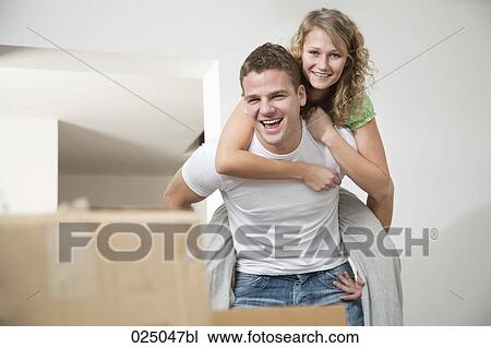 young man giving woman piggback ride in new home View Large Photo Image Stock Image - young man giving woman piggback ride in new home. Fotosearch