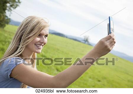 young woman making self-portrait with mobile phone View Large Photo Image Stock Image - young woman making self-portrait with mobile phone. Fotosearch