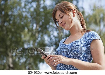 young woman reading text message on mobile phone View Large Photo Image Stock Image - young woman reading text message on mobile phone. Fotosearch