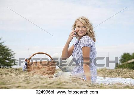 young woman talking on mobile phone in field View Large Photo Image Stock Image - young woman talking on mobile phone in field. Fotosearch