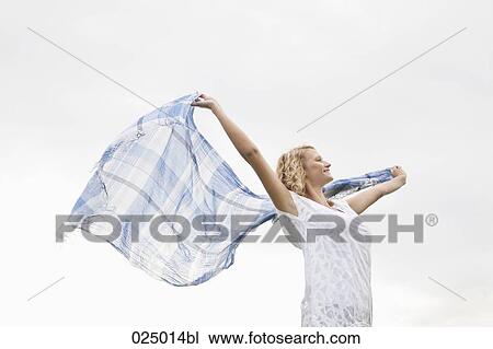 young woman waving cloth through the air View Large Photo Image Stock Image - young woman waving cloth through the air. Fotosearch