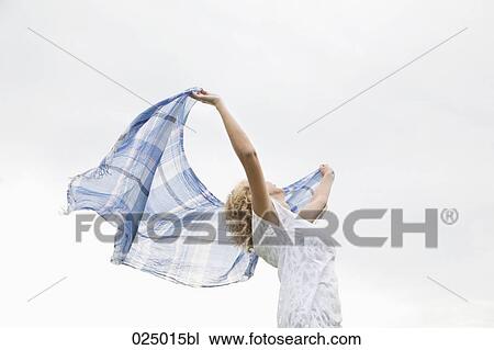 Stock Image - young woman waving cloth through the air. Fotosearch