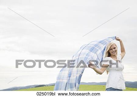 young woman waving cloth through the air View Large Photo Image Stock Image - young woman waving cloth through the air. Fotosearch