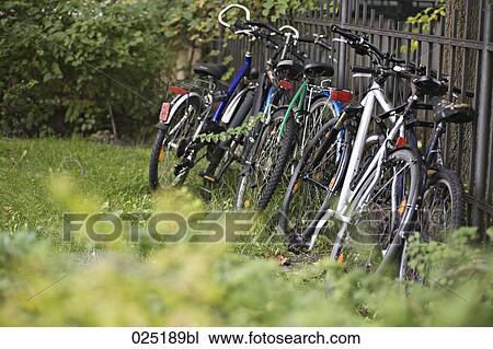 Stock Image - bicycles leaning against fence. Fotosearch