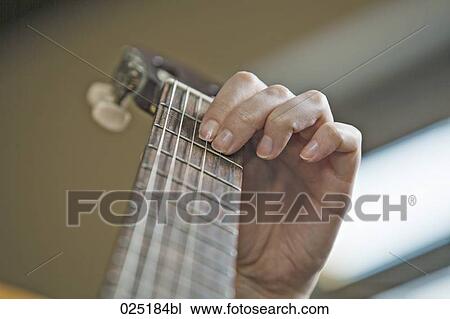 Stock Image - close-up of young woman playing guitar. Fotosearch
