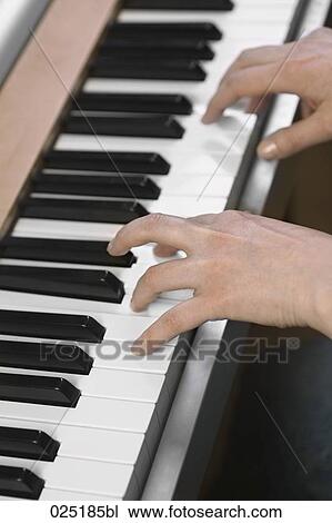 Stock Image - close-up of young woman playing keyboard. Fotosearch