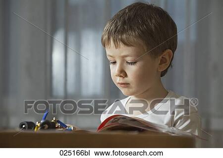Stock Image - portrait of young boy reading. Fotosearch