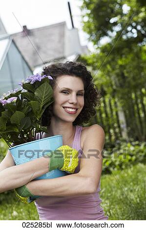 portrait of young woman holding flowerpot View Large Photo Image Stock Image - portrait of young woman holding flowerpot. Fotosearch
