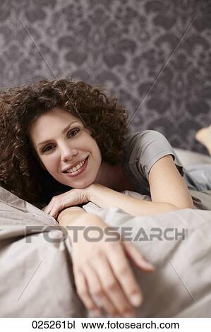 Stock Image - portrait of young woman in bed. Fotosearch