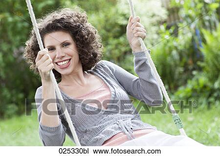 portrait of young woman in garden on swing View Large Photo Image Stock Image - portrait of young woman in garden on swing. Fotosearch