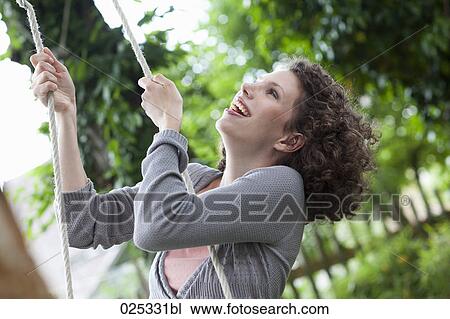 portrait of young woman in garden on swing View Large Photo Image Stock Image - portrait of young woman in garden on swing. Fotosearch