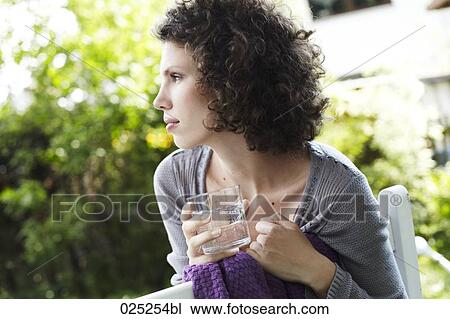 portrait of young woman in garden with glass of water View Large Photo Image Stock Image - portrait of young woman in garden with glass of water. Fotosearch