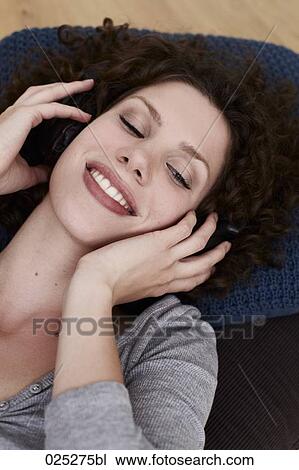 Stock Image - portrait of young woman listening to music. Fotosearch
