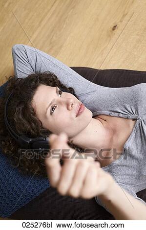 Stock Image - portrait of young woman listening to music. Fotosearch