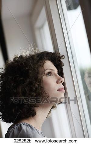 portrait of young woman looking out of window View Large Photo Image Stock Image - portrait of young woman looking out of window. Fotosearch