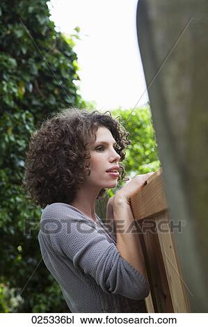 portrait of young woman looking over garden fence View Large Photo Image Stock Image - portrait of young woman looking over garden fence. Fotosearch
