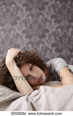 portrait of young woman lying in bed View Large Photo Image Stock Image - portrait of young woman lying in bed. Fotosearch