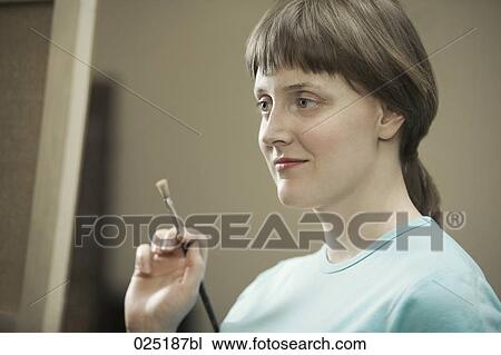 Stock Image - portrait of young woman painting. Fotosearch