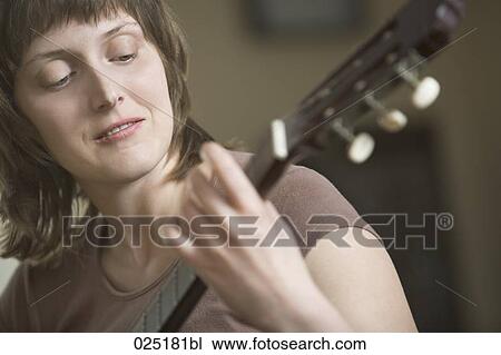portrait of young woman playing guitar View Large Photo Image Stock Image - portrait of young woman playing guitar. Fotosearch