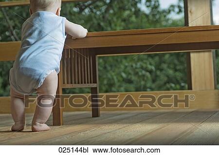 rear view of baby in living room standing at table View Large Photo Image Stock Image - rear view of baby in living room standing at table. Fotosearch