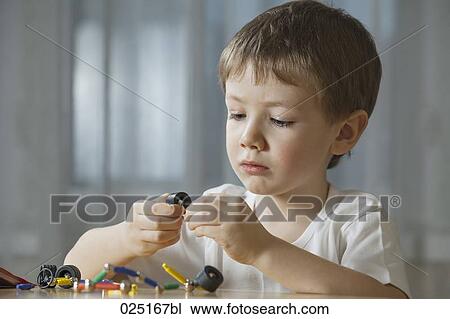 Stock Image - young boy playing with shape game. Fotosearch