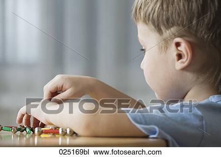 Stock Image - young boy playing with shape game. Fotosearch