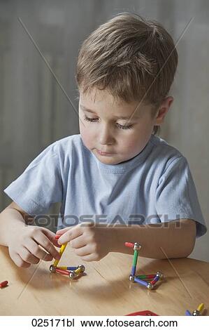 Stock Image - young boy playing with shape game. Fotosearch