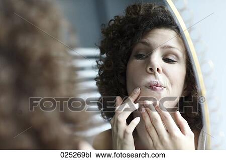 young woman checking her face in the mirror View Large Photo Image Stock Image - young woman checking her face in the mirror. Fotosearch