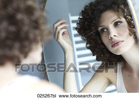 young woman checking her hair in the mirror View Large Photo Image Stock Image - young woman checking her hair in the mirror. Fotosearch
