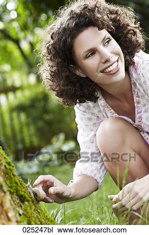 young woman in garden watching snail View Large Photo Image Stock Image - young woman in garden watching snail. Fotosearch