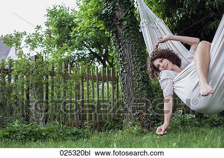young woman lying in hammock in garden View Large Photo Image Stock Image - young woman lying in hammock in garden. Fotosearch