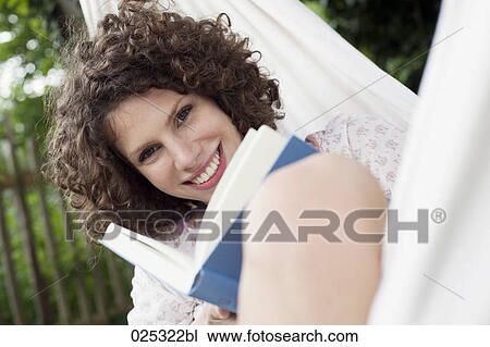 young woman lying in hammock in garden reading View Large Photo Image Stock Image - young woman lying in hammock in garden reading. Fotosearch