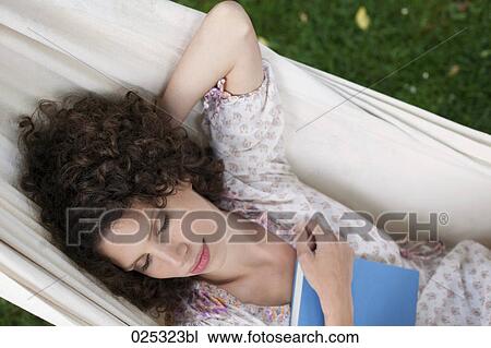 young woman lying in hammock in garden sleeping View Large Photo Image Stock Image - young woman lying in hammock in garden sleeping. Fotosearch